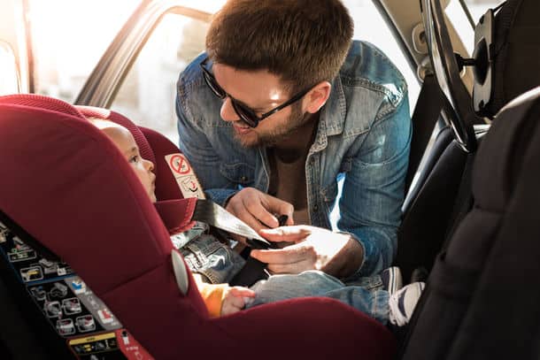 Father Fasten His Little Baby In The Car Seat