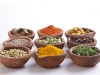 Variety Of Indian Spices In Diyas Over White Background