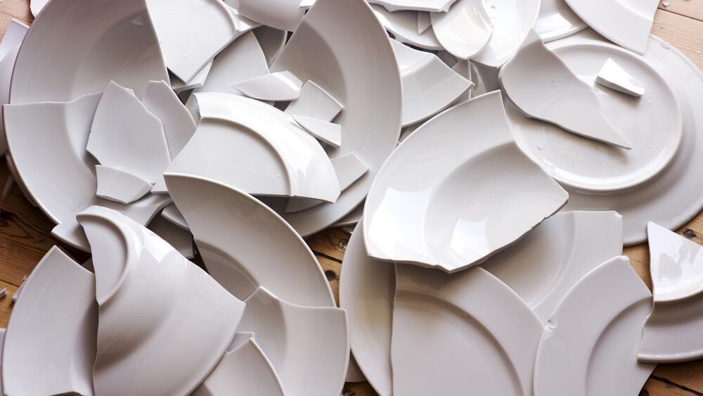 many broken white plates on the floor