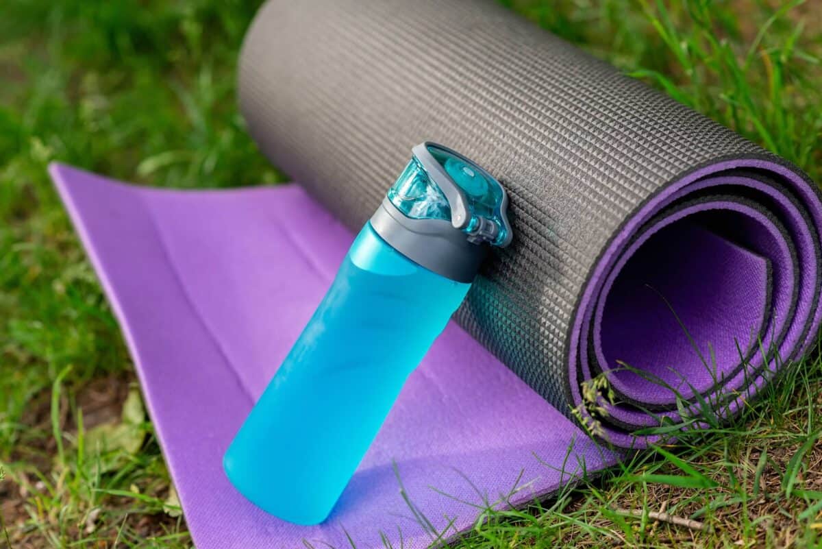 fitness mat and water bottle, on grass