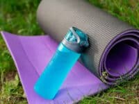 fitness mat and water bottle, on grass