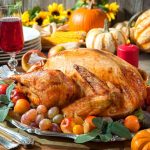 Thanksgiving dinner. Roasted turkey on holiday table with pumpkins, flowers and wine