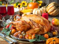 Thanksgiving dinner. Roasted turkey on holiday table with pumpkins, flowers and wine