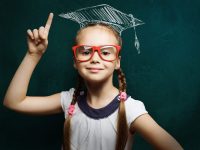 small girl in red glasses and graduation cap