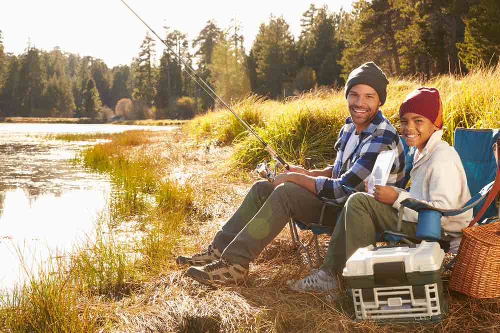 father and son fishing in lake