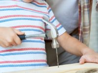 closeup of a child hammering a nail