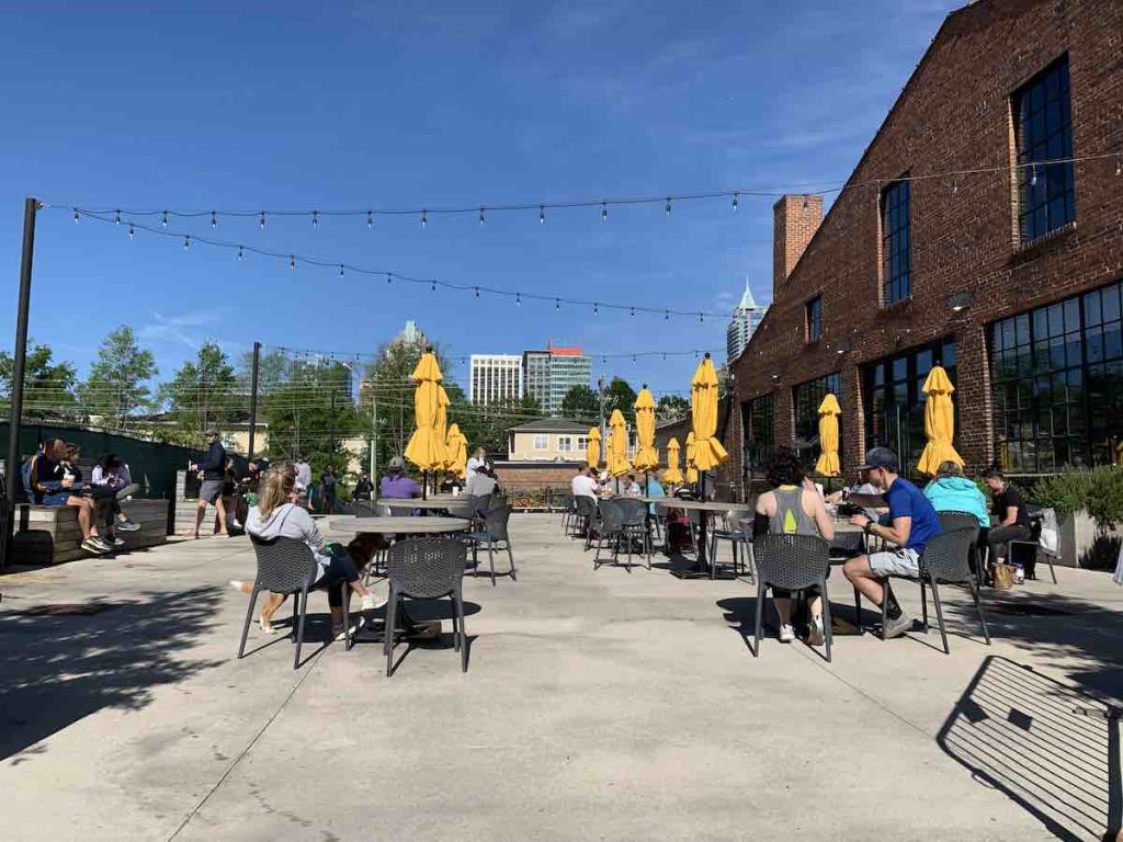 patios with table with yellow umbrellas at transfer co food hall in raleigh