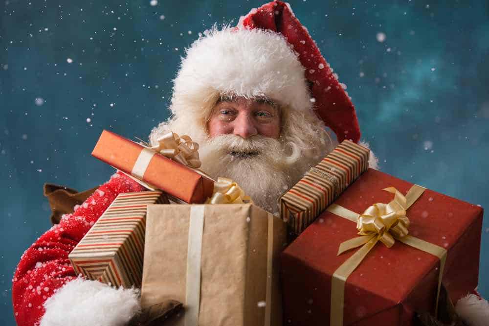 Santa holding many gifts