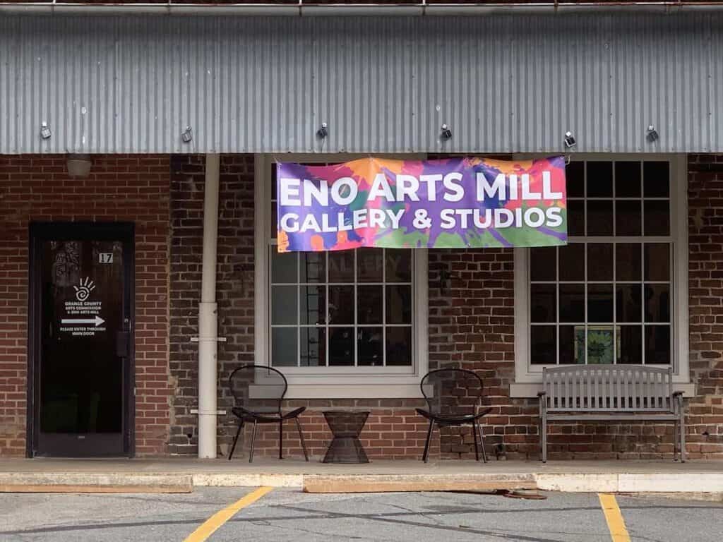 Exterior of Eno Arts Mill, with colorful sign and brick buildings