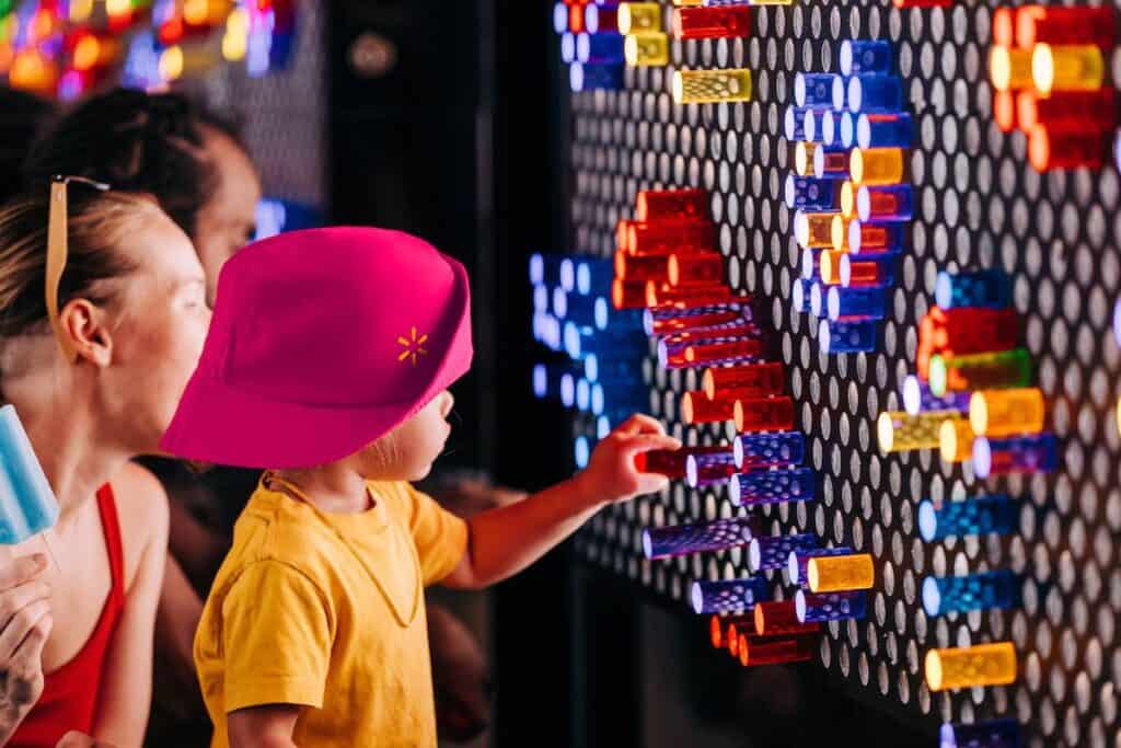 Child placing a peg in a large-scale light project