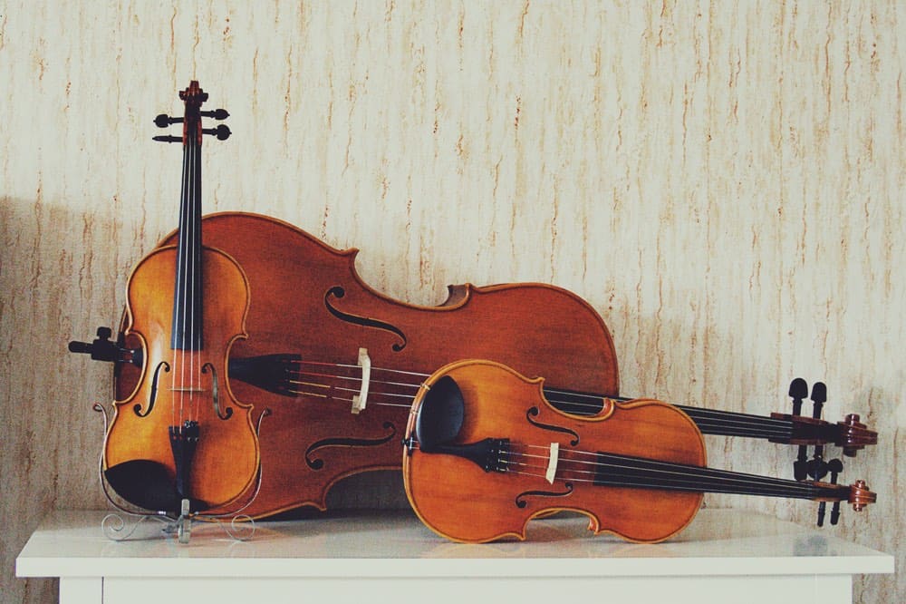 violin, viola and cello on a table