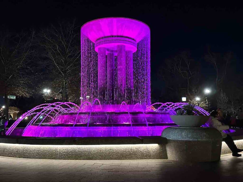 The fountain at Downtown Cary Park, lit up at night