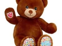 Brown stuffed bear with "happy birthday" on foot