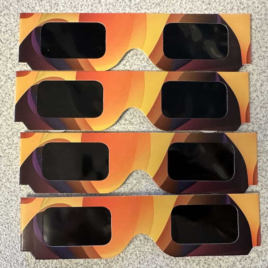 four pairs of solar eclipse glasses