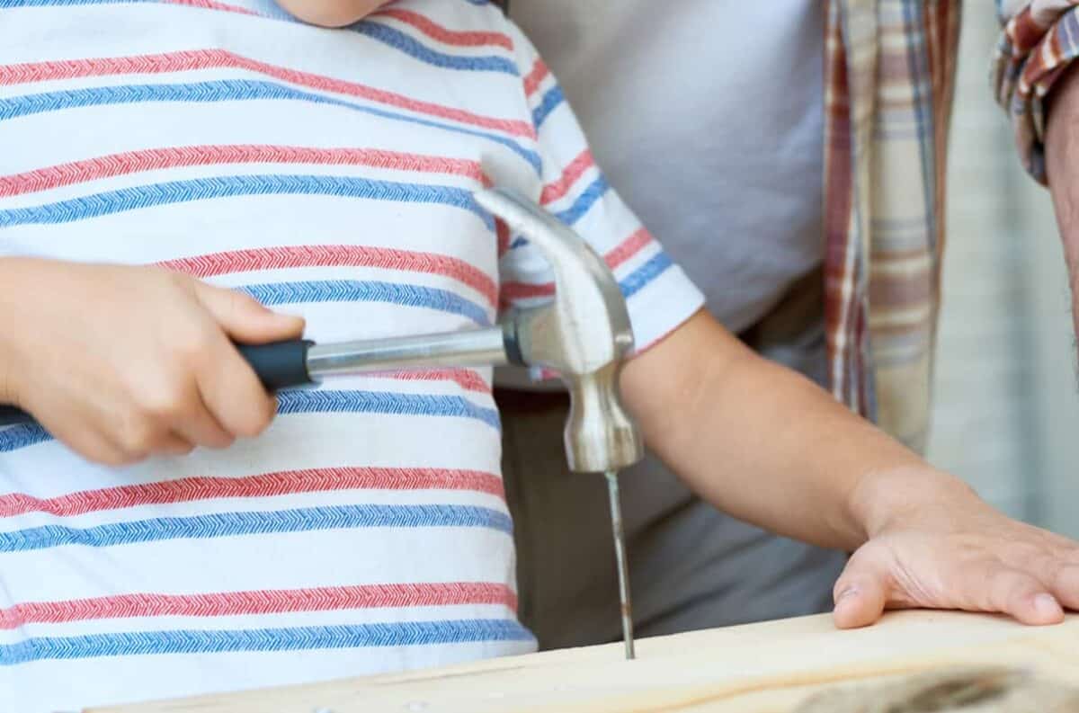 closeup of a child hammering a nail