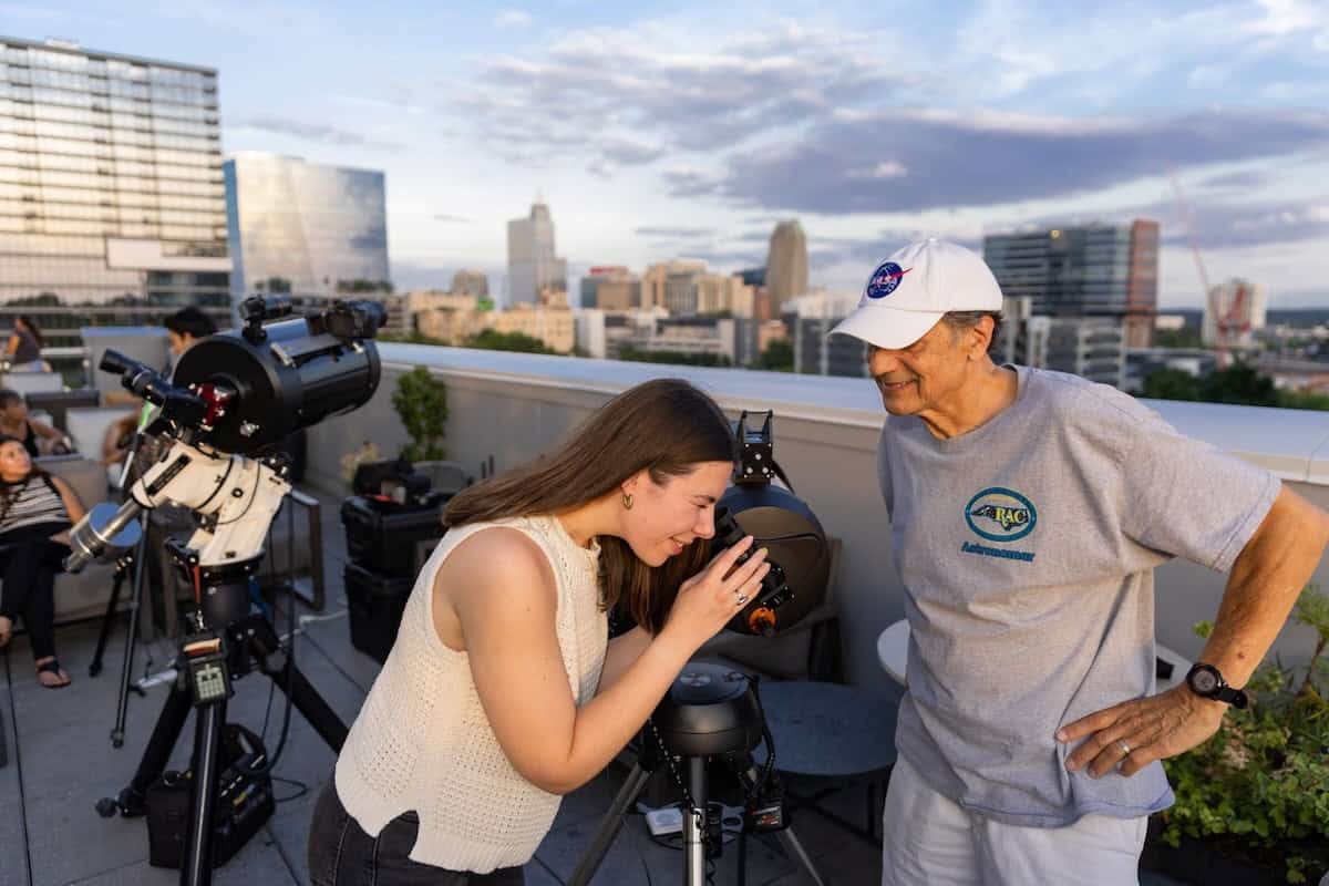 woman looking through telescope
