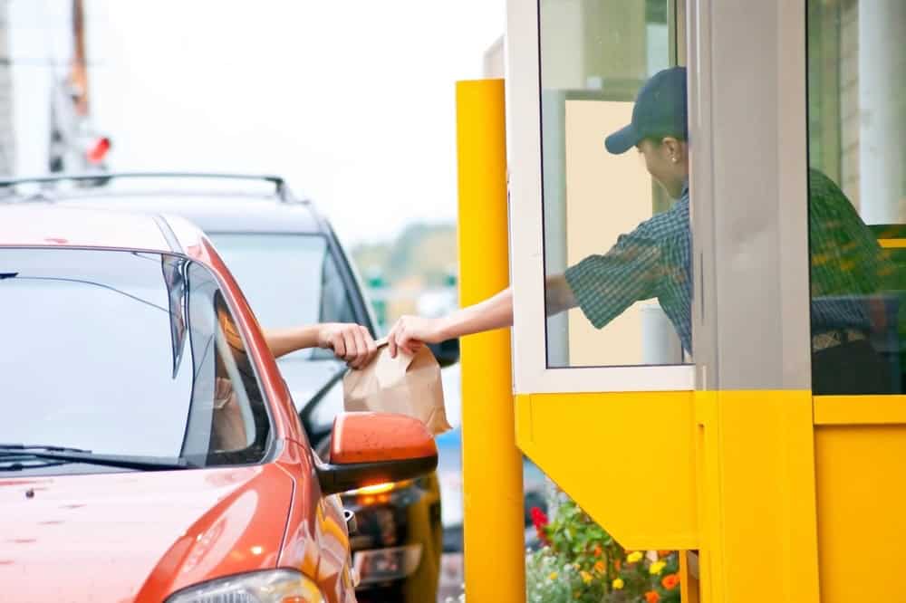 customer receiving bag of food at drive-thru window