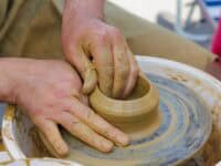 potter working with clay on pottery wheel