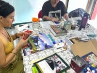 People at a table working on a collage