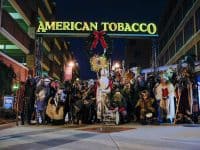 group of people under American Tobacco sign, dressed as Krampus