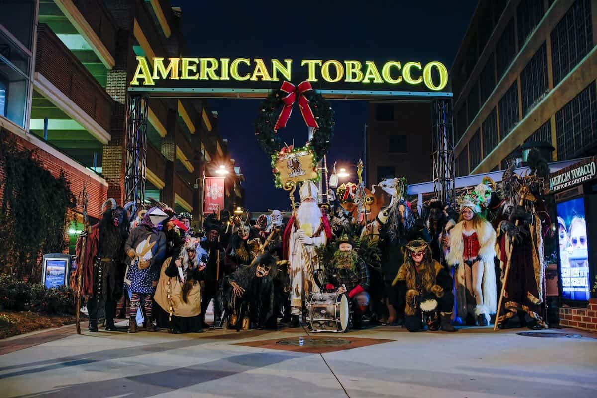 group of people under American Tobacco sign, dressed as Krampus