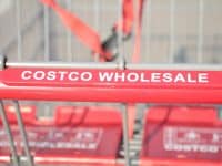 closeup of shopping card with red handle labeled Costco Wholesale