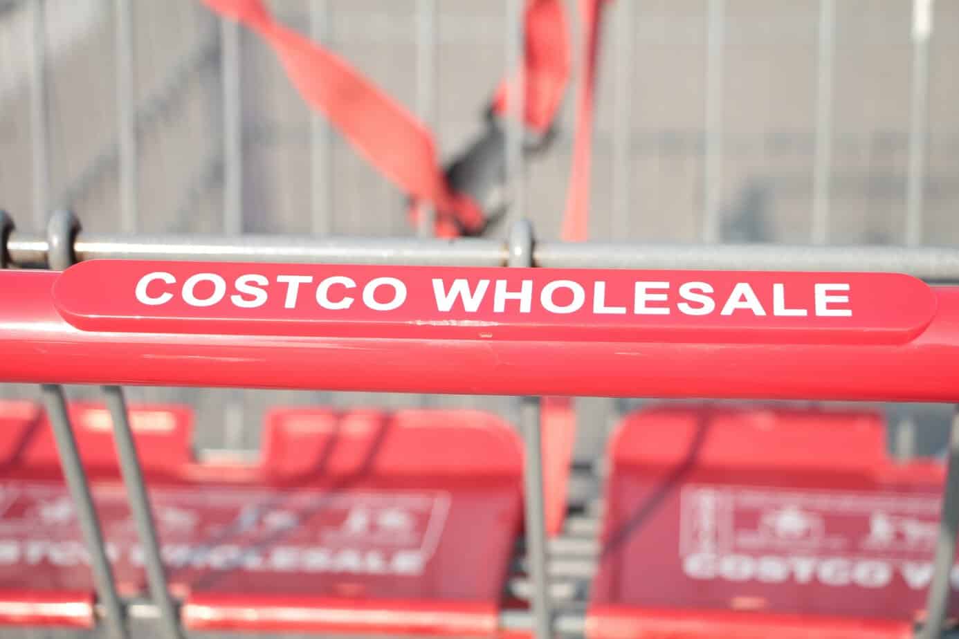 closeup of shopping card with red handle labeled Costco Wholesale