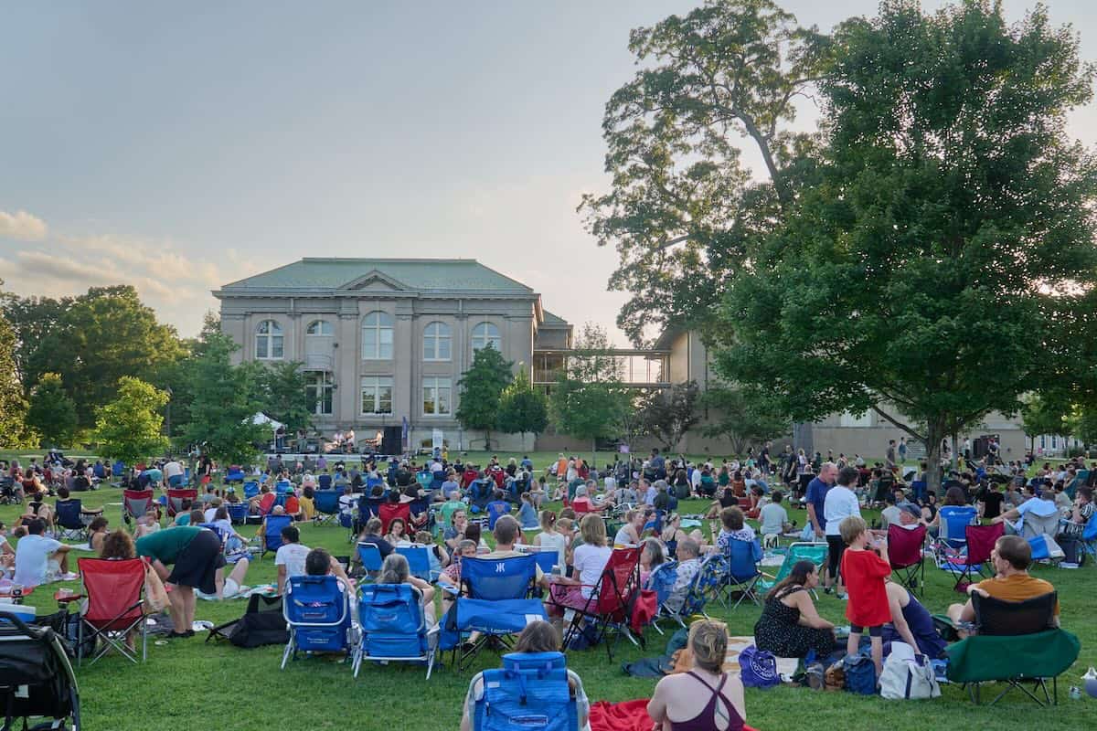 people listening to a concert on a lawn