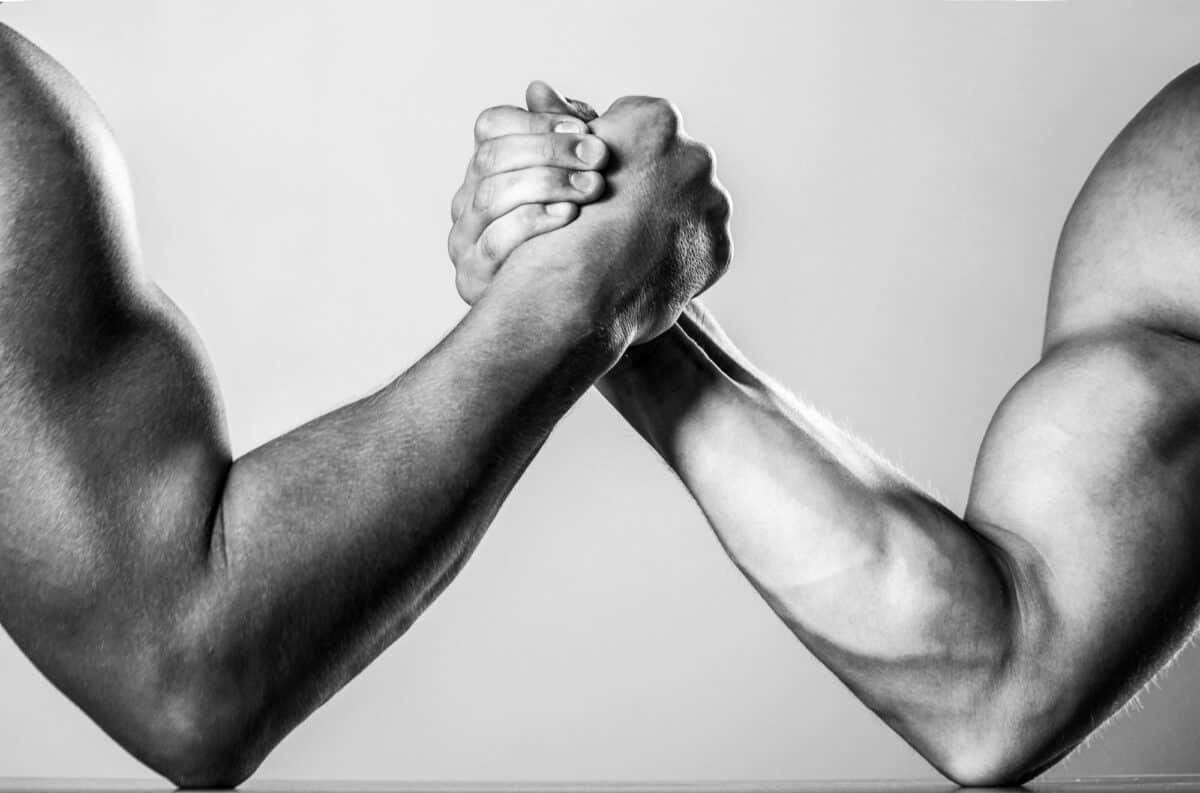 Muscular men arm wrestling