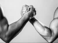 Muscular men arm wrestling