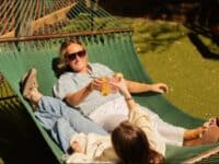 2 people in a big hammock with drinks