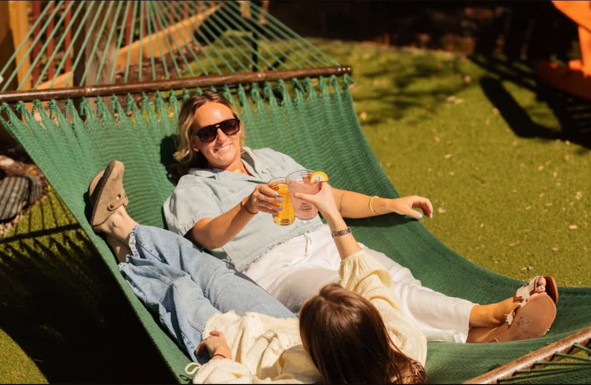 2 people in a big hammock with drinks